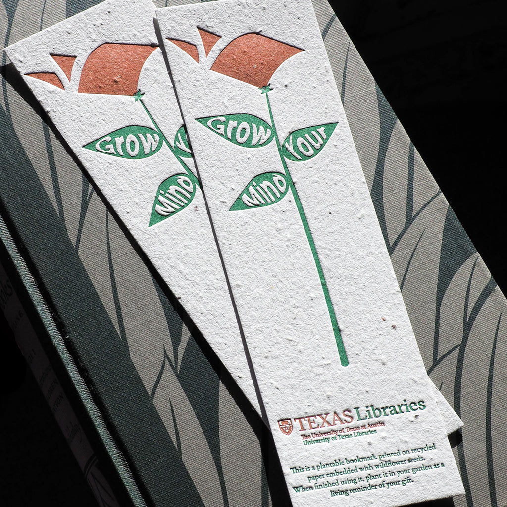 two seeded two color letterpress bookmarks on top of book